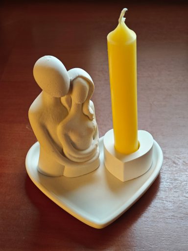 Liebespaar mit Kerze auf Herzschale